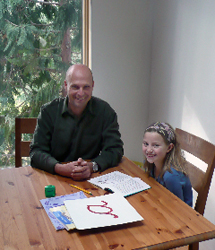 Bill Baldyga at a table with a young student